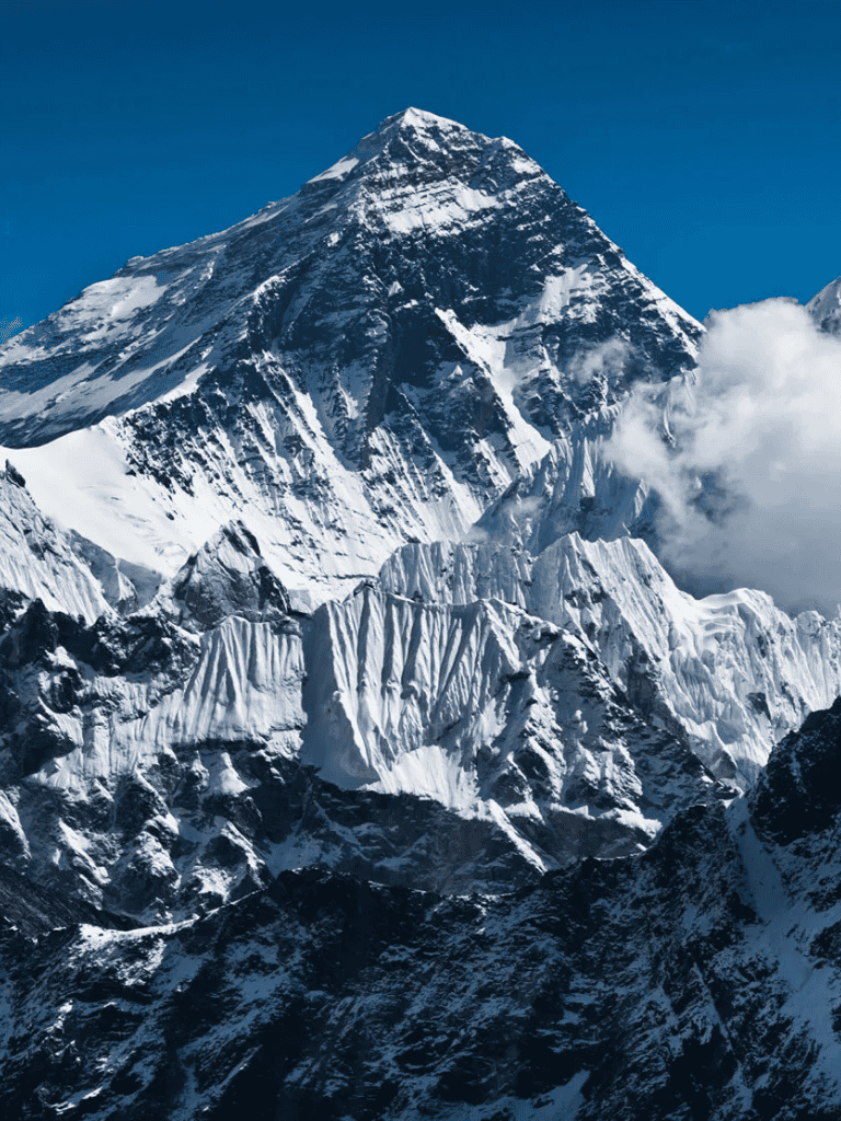 Majestic snow-covered mountain peak with clear blue sky backdrop.