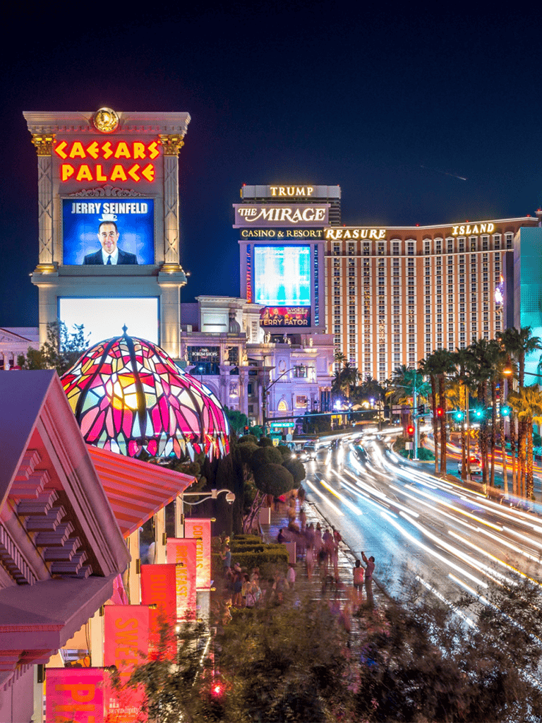 Caesars Palace Las Vegas Strip night scene with bright city lights and iconic landmarks.