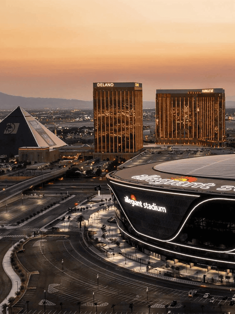 Elegant stadium at sunset in Las Vegas with city skyline in the background.