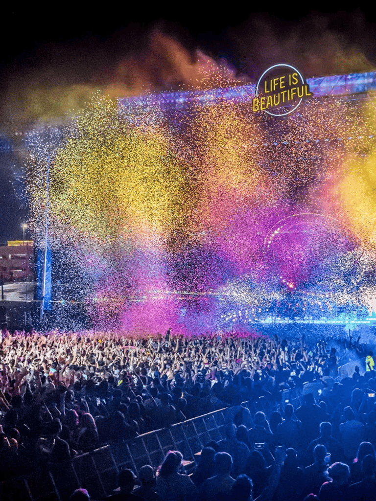 Vibrant concert crowd with colorful confetti and stage lighting at QuestForDirections event.