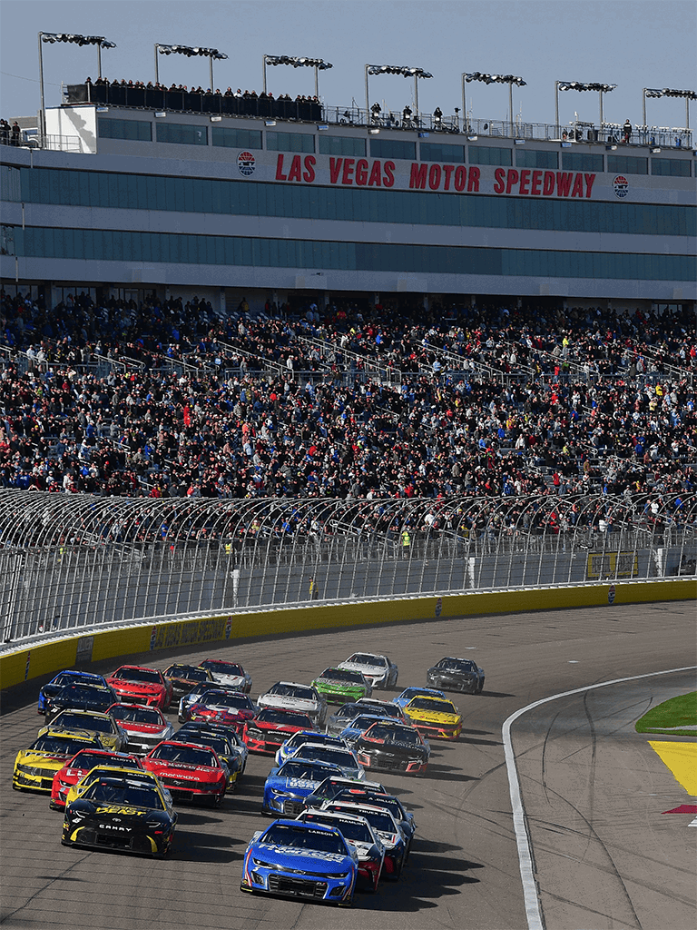 Race cars at Las Vegas Motor Speedway during a NASCAR race event.