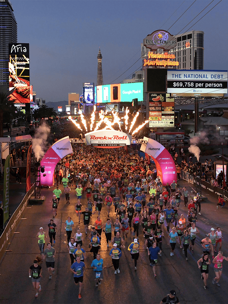 Runners participating in the Las Vegas Rock 'n' Roll Marathon at night streets.