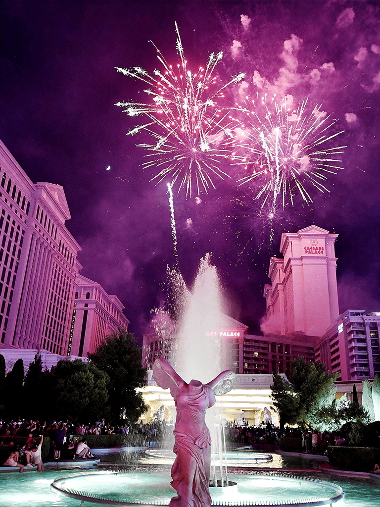 Bright fireworks over Caesars Palace Las Vegas at night, celebrating with a colorful display.