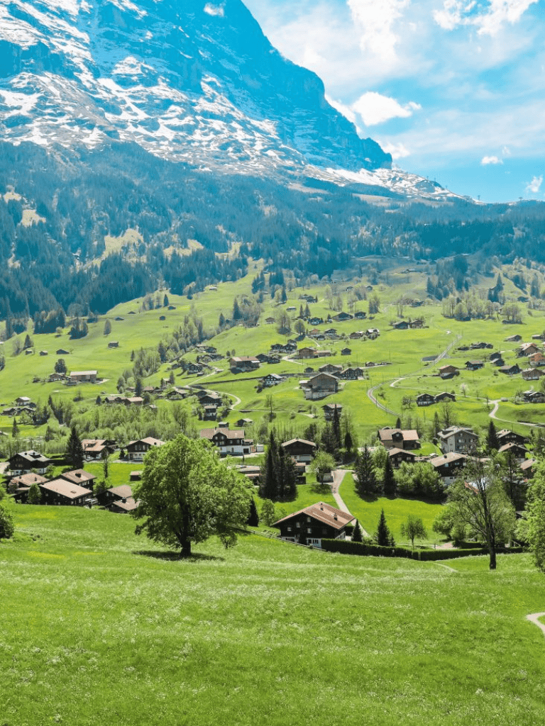 Mountainside village with lush green meadows and winding roads scenic travel destination.