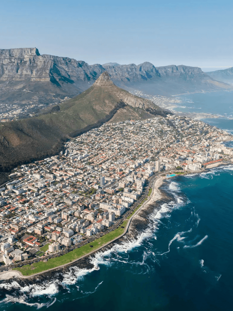 Aerial view of Cape Town cityscape with Table Mountain in the background, scenic coastal city in South Africa.
