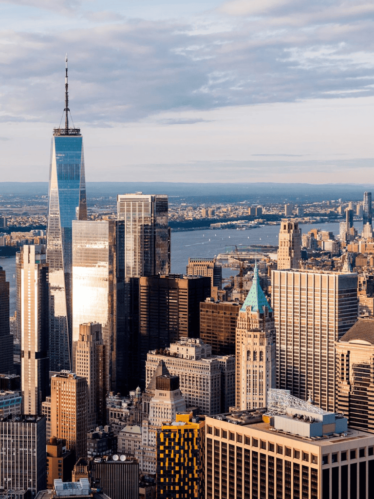 Sprawling New York City skyline with One World Trade Center and Hudson River in view.