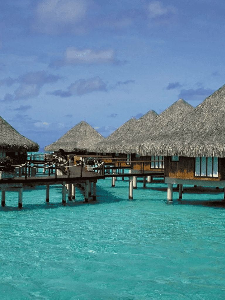 Overwater bungalows in turquoise lagoon, tropical paradise, overwater villas, scenic oceanfront resort, vacation in Maldives.