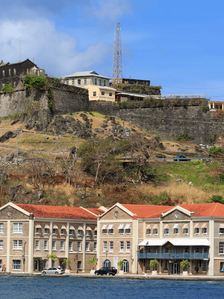 Cliffside buildings with communication tower and waterfront apartments, scenic views, and urban development in a coastal city.