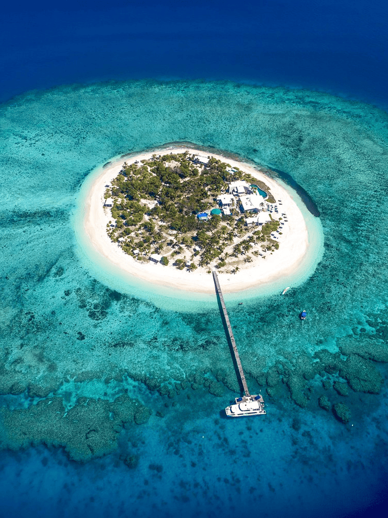 Secluded island paradise with overwater dock and crystal-clear waters.