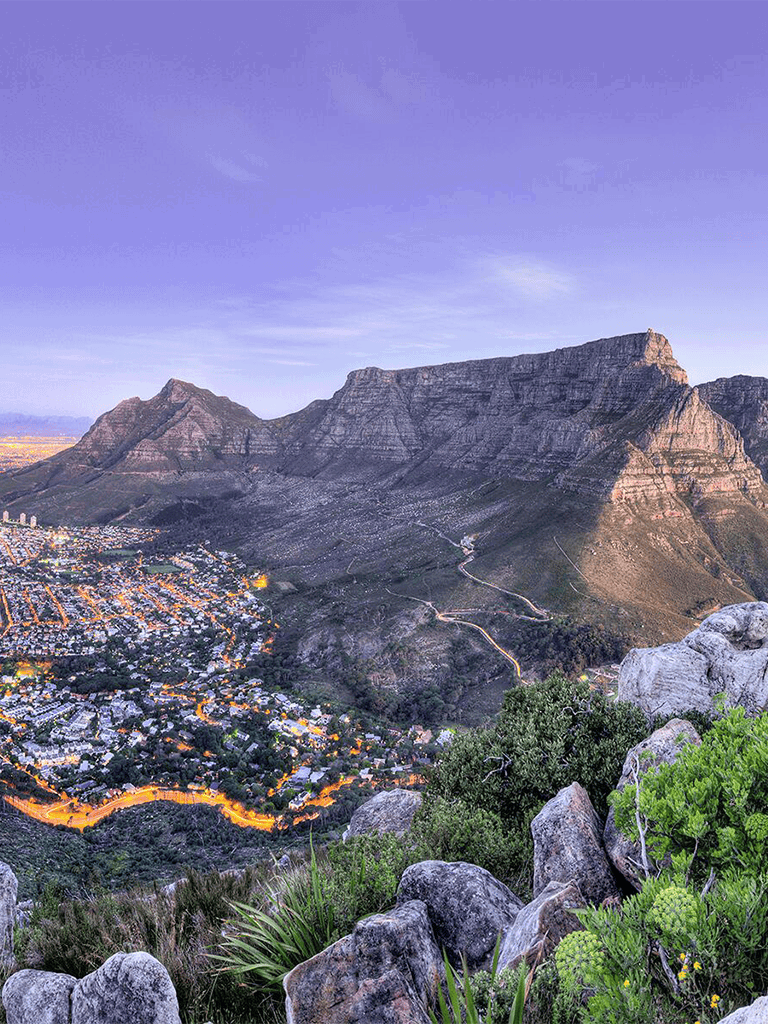Breathtaking view of Table Mountain and Cape Town city lights at dusk, South Africa.