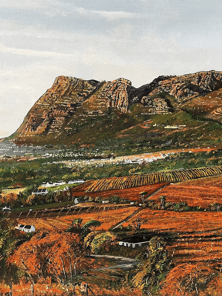 Vineyard landscape with mountains and colorful autumn foliage in the background.