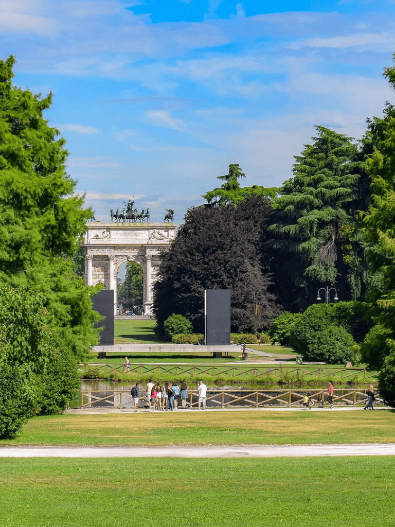 Lush park with historic monument in the background, popular for sightseeing and outdoor activities.
