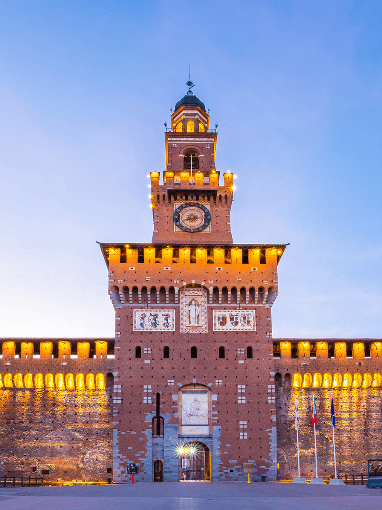 Majestic illuminated medieval castle tower in Italy at dusk.