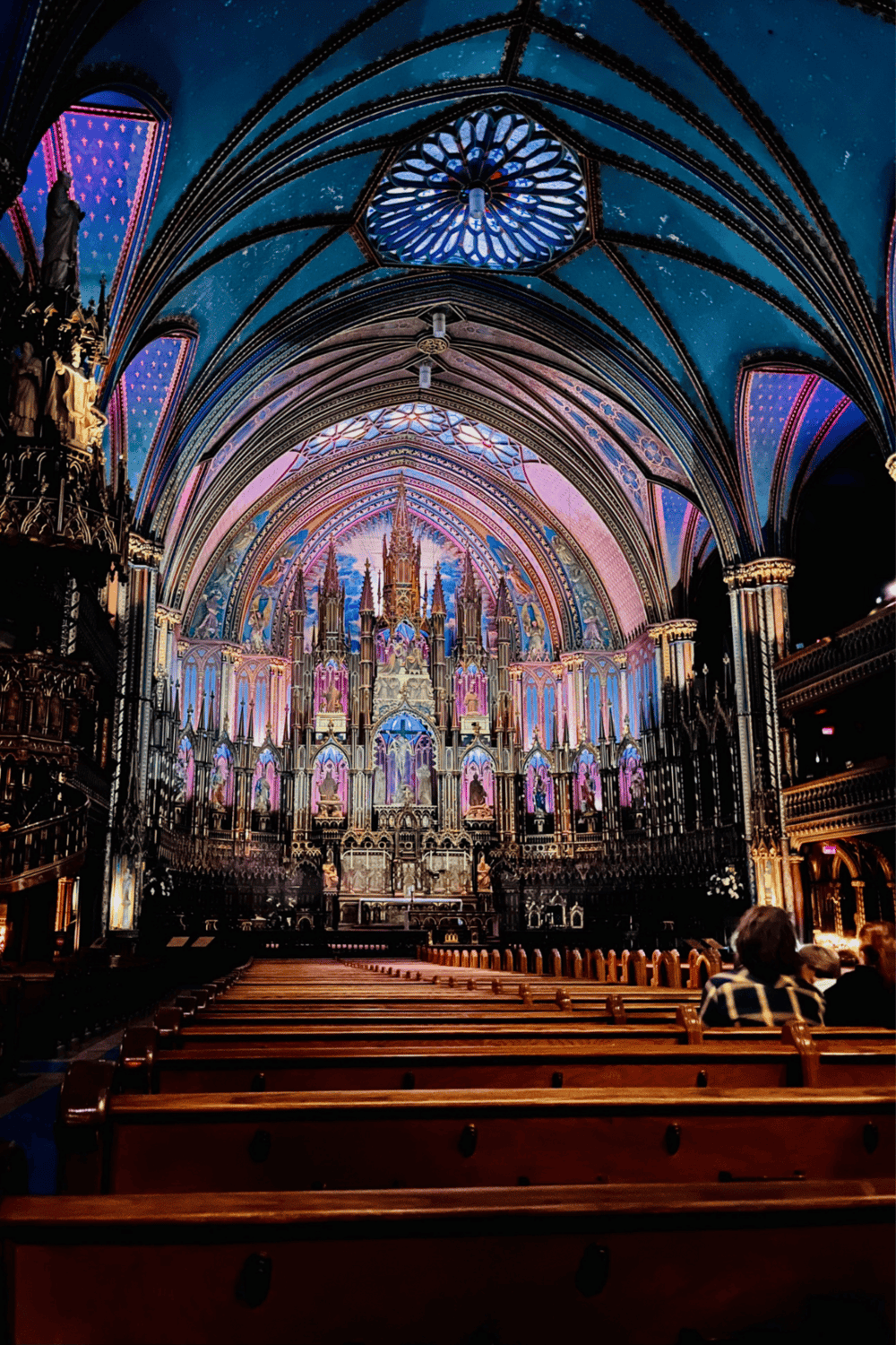 Holy Gothic cathedral interior with stained glass, ornate architecture, and vibrant colorful projections for sightseeing.