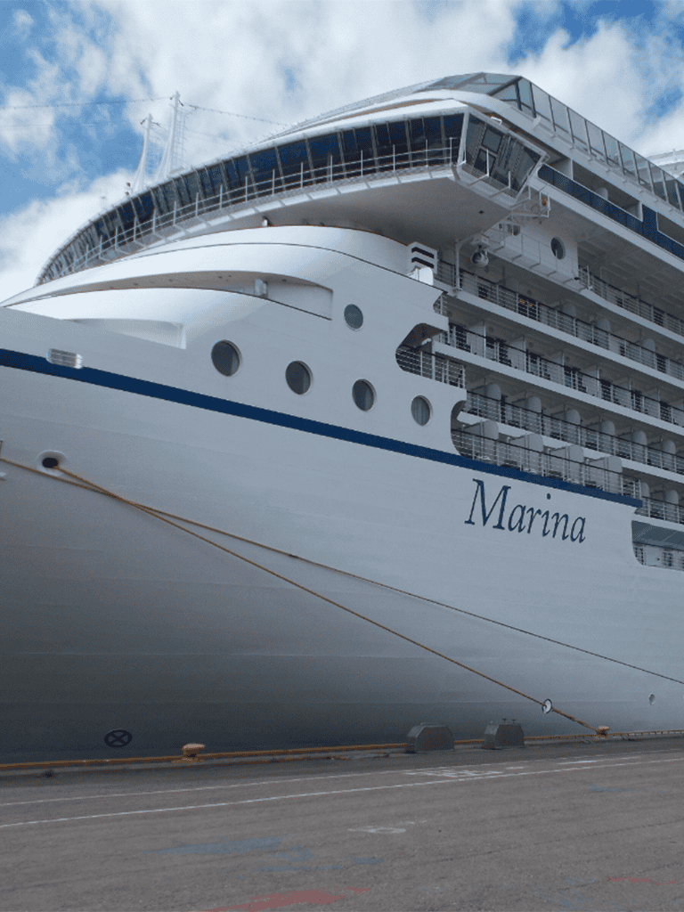 Luxury cruise ship docked at port, traveling with QuestForDirections for maritime navigation.