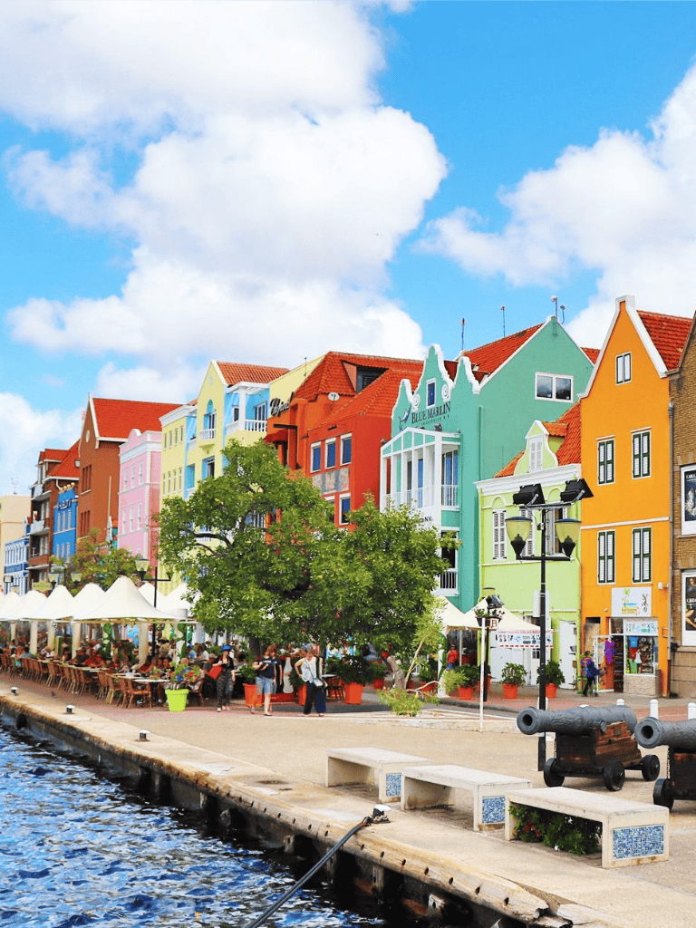 Colorful European waterfront buildings and lively outdoor cafes in the Netherlands.