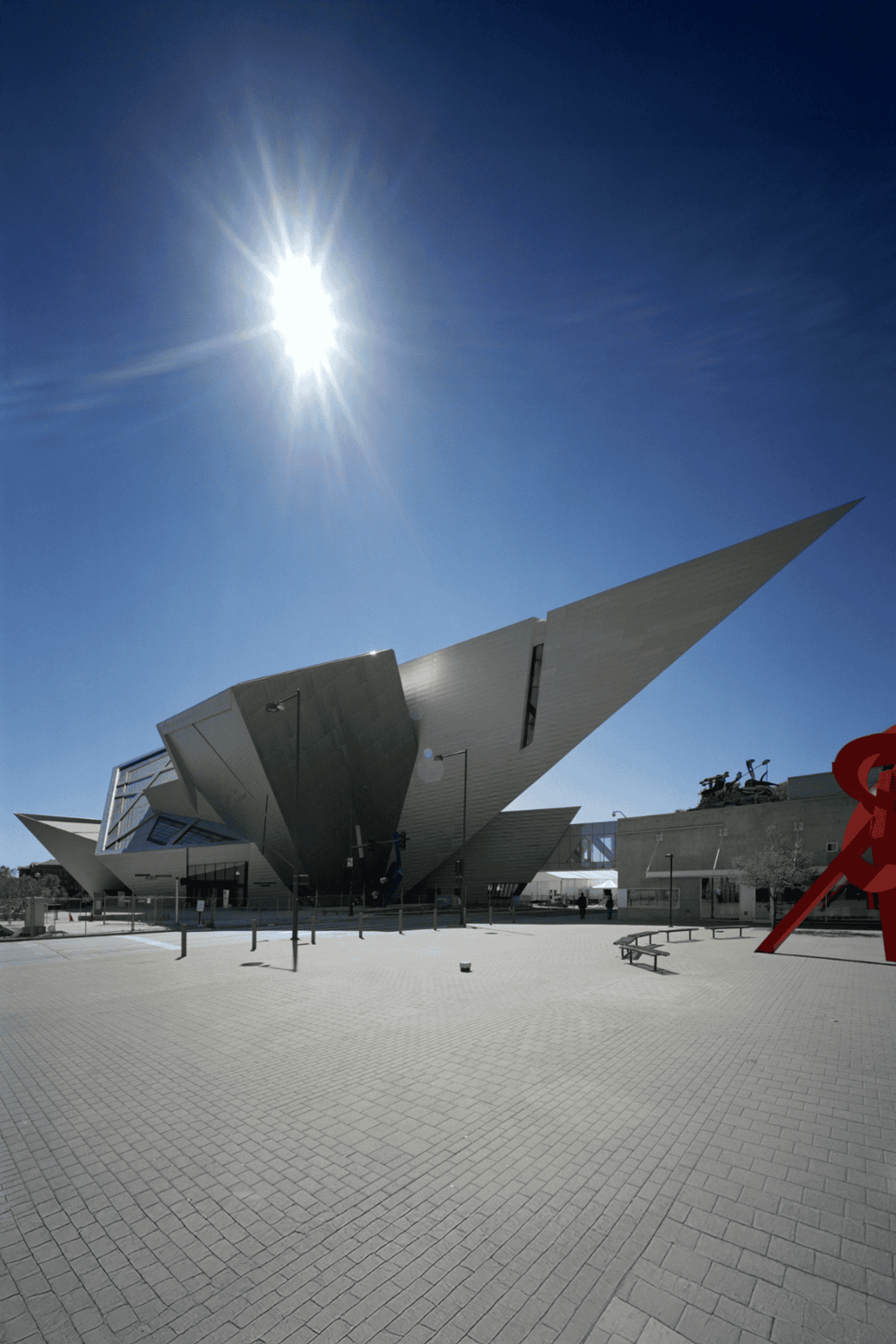 Modern architectural building showcasing innovative design and structure, with bright sunlight illuminating the scene.