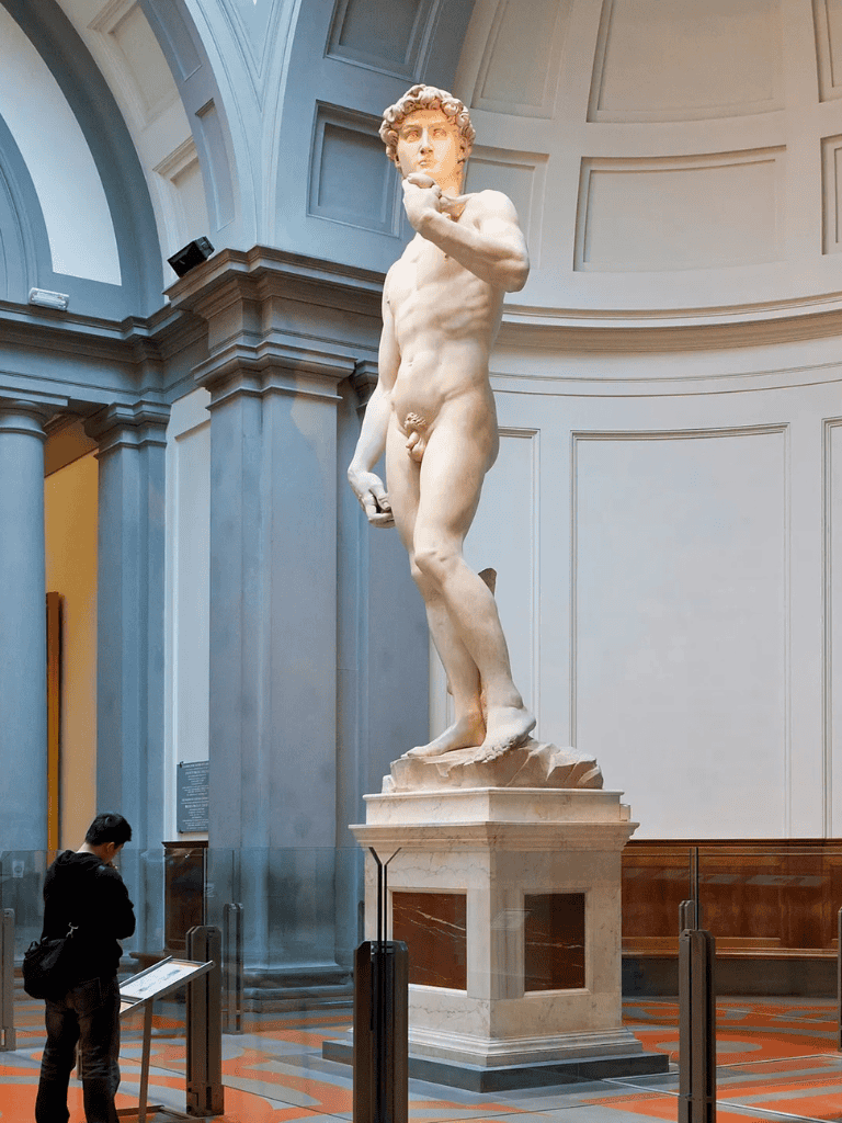 Ancient Greek statue of David sculpture displayed in museum interior.