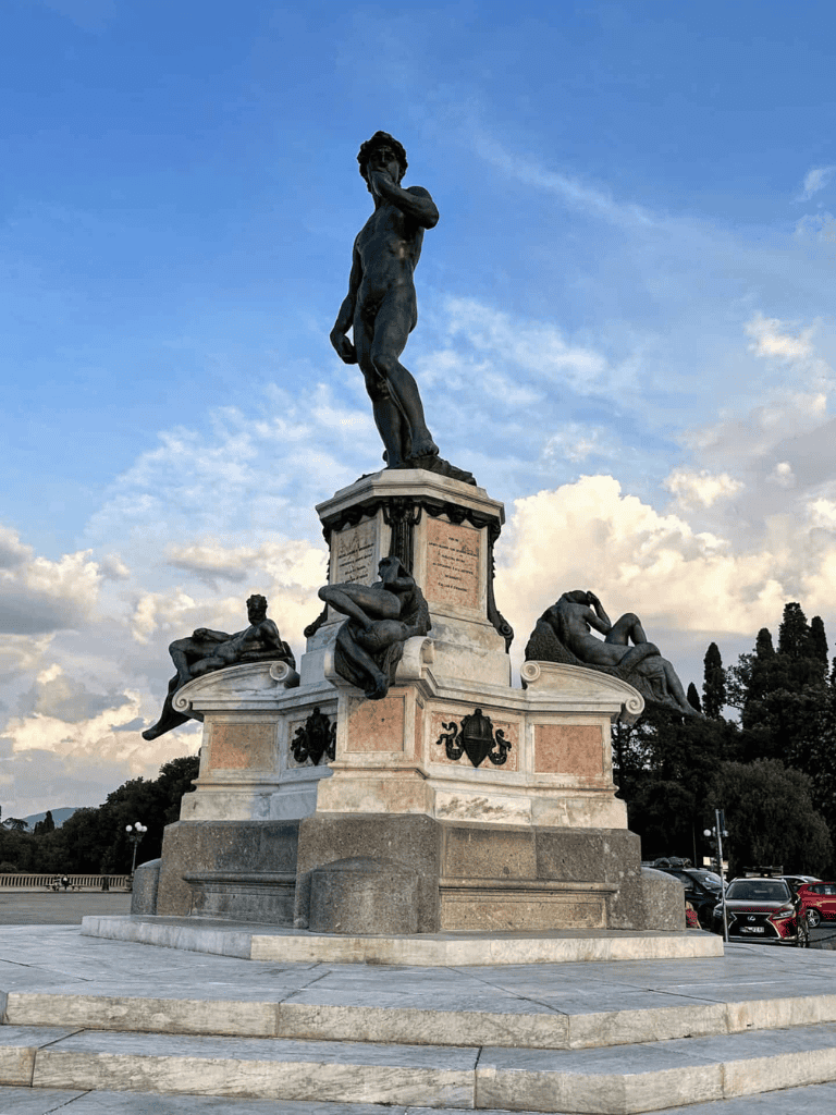 Intriguing statue of a mythological figure with surrounding sculptures, situated in a scenic outdoor park setting.