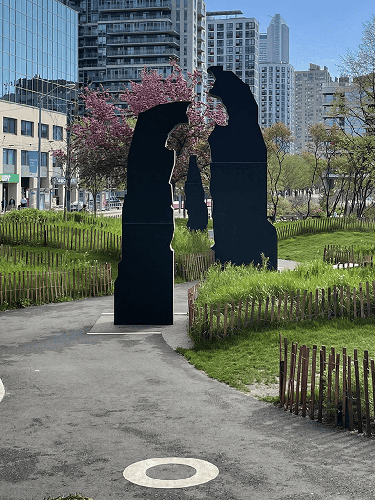 Silhouette statue of two bears with cityscape background in urban park, QuestForDirections.