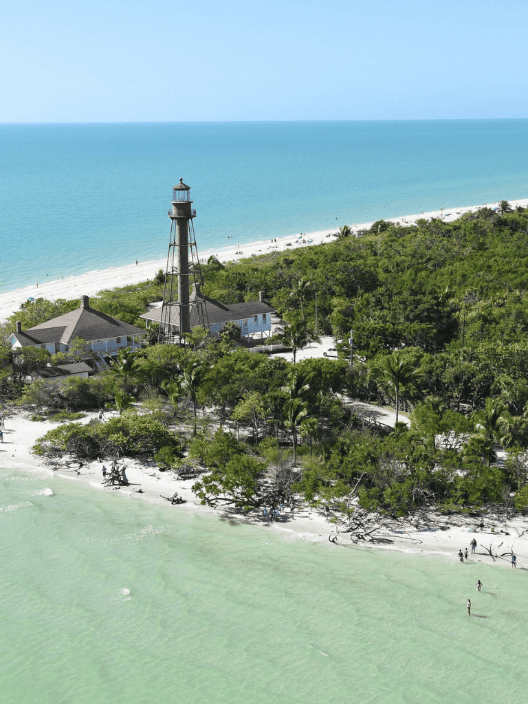Lighthouse near the beach on a sunny day, coastal scenery, vacation destination, coastal navigation, seaside travel.