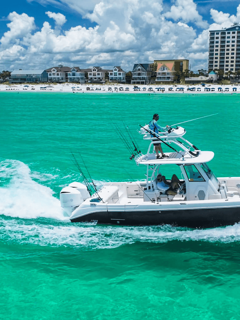 Luxury fishing boat on turquoise waters near coastal houses and resorts, adventure, ocean, water sport.