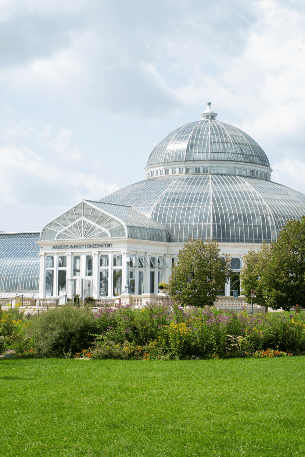 Glass conservatory at Marjorie McNefly Conservatory, botanical garden, floral displays, outdoor greenery, scenic botanical conservatory in the city.