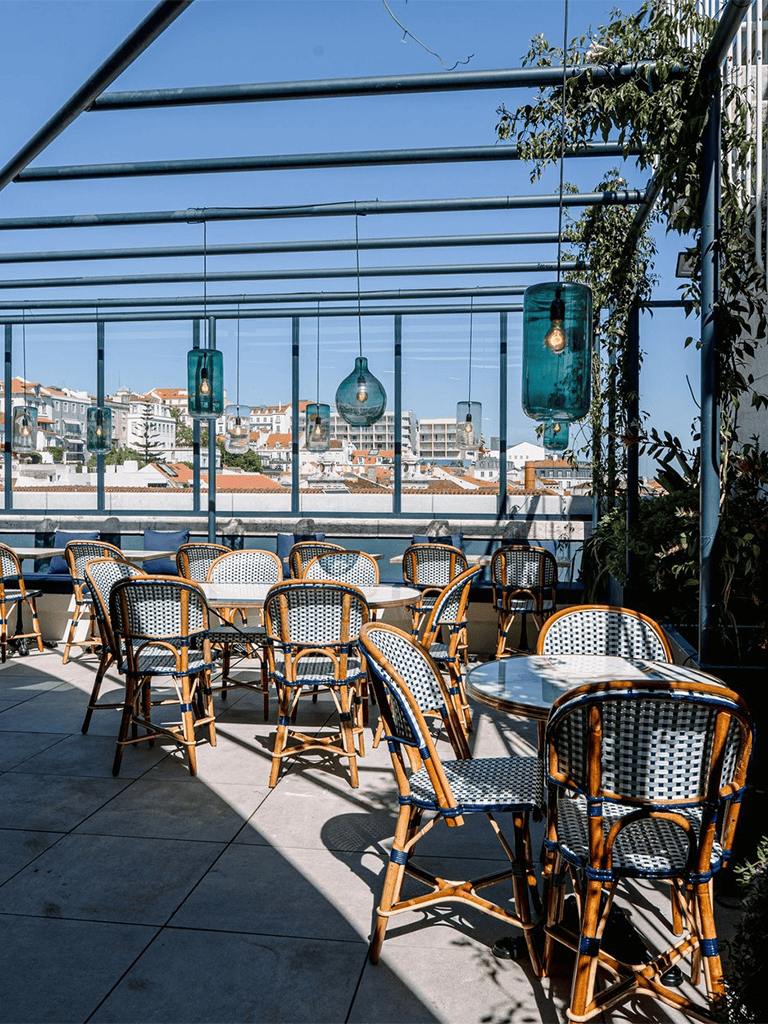 Modern rooftop restaurant with outdoor seating and city views for dining and social events.