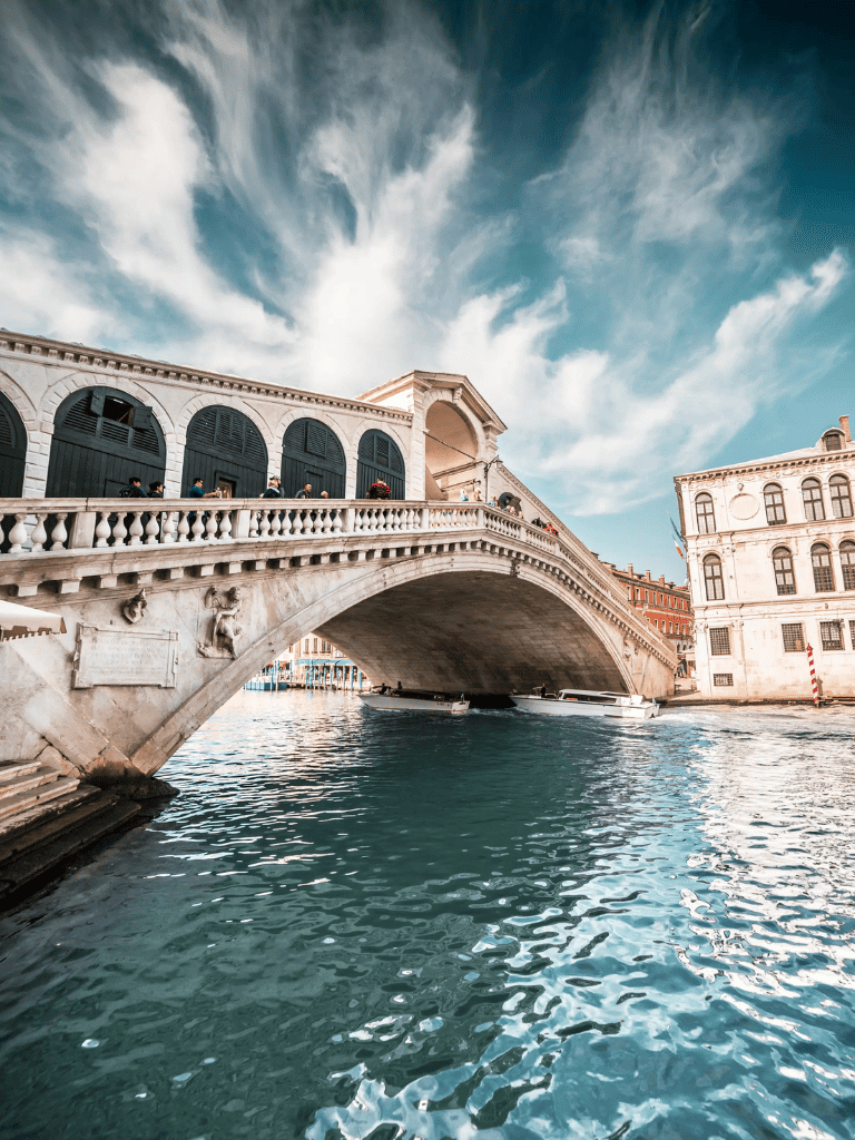 Historic Venice Bridge over Canal, Italy, scenic cityscape with water traffic and architecture.