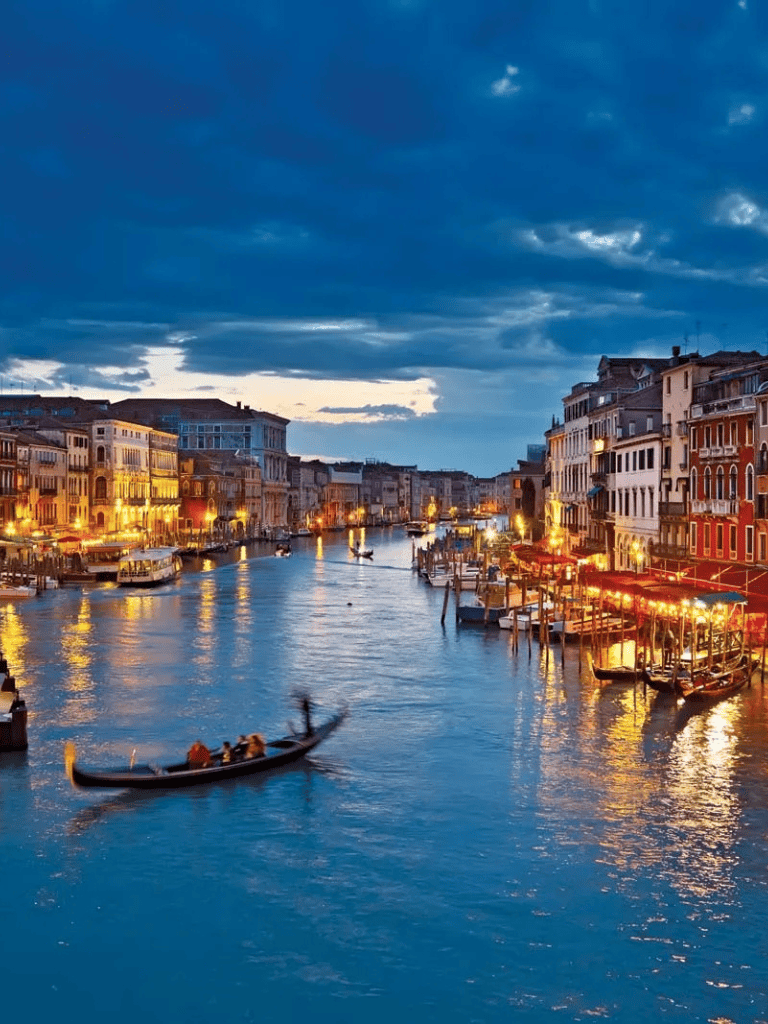 Beautiful Venice canal at dusk with gondolas and historic buildings, perfect for travel planning and navigation.