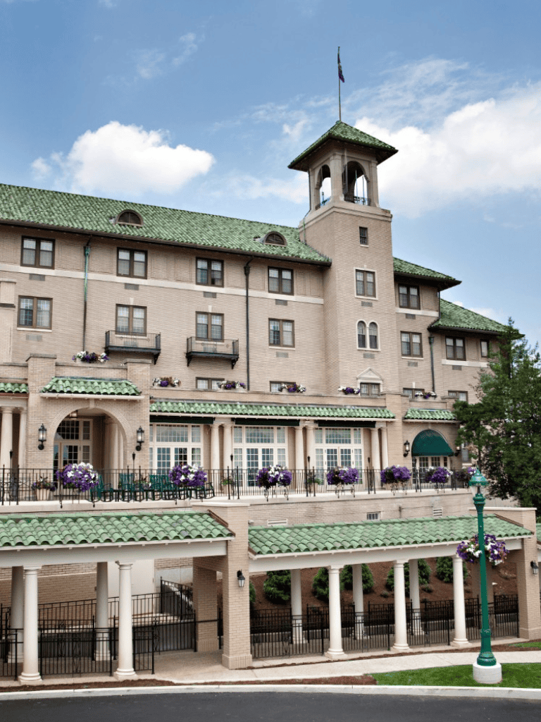 Elegant hotel building with green tiled roofs and floral decorations, perfect for luxury accommodations.
