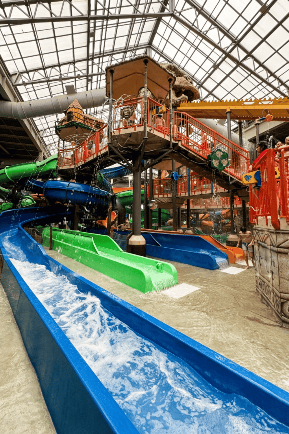 Water park with multiple colorful slides and an indoor play area, suitable for family fun and recreation.