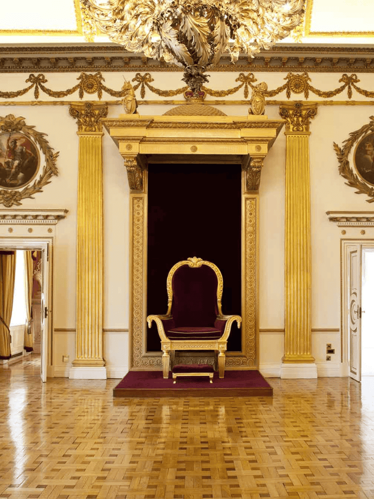 Luxurious royal throne in ornate gilded room with elegant decor and historical grandeur.