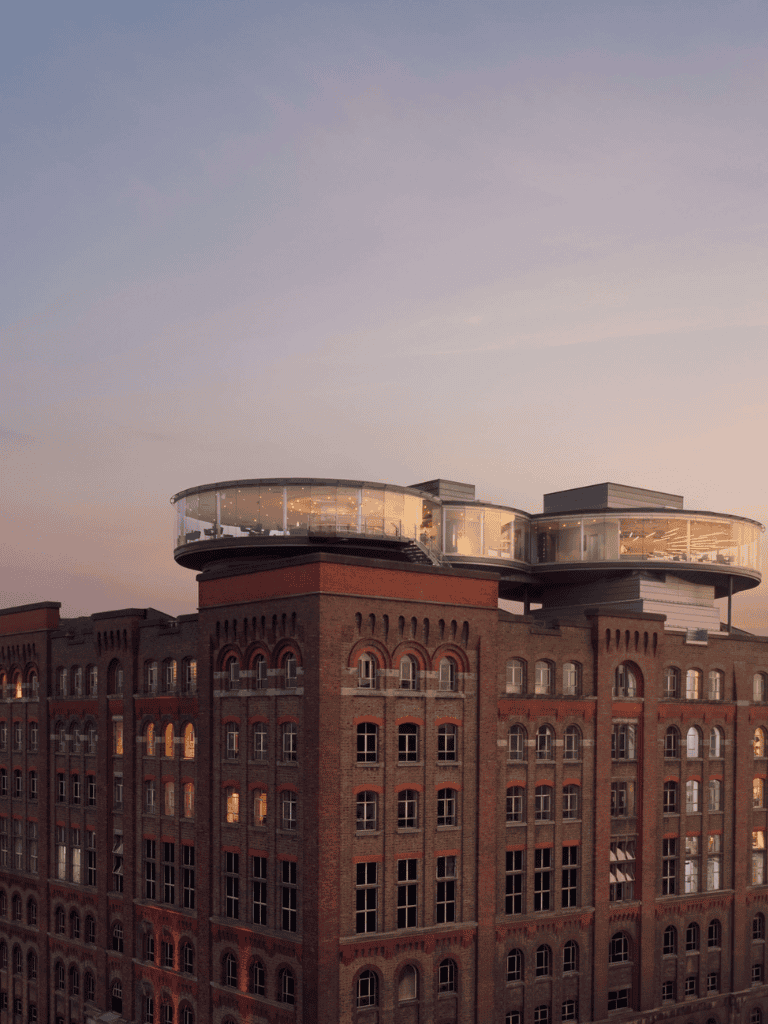 Modern urban building with innovative glass rooftop extension for cityscape views.