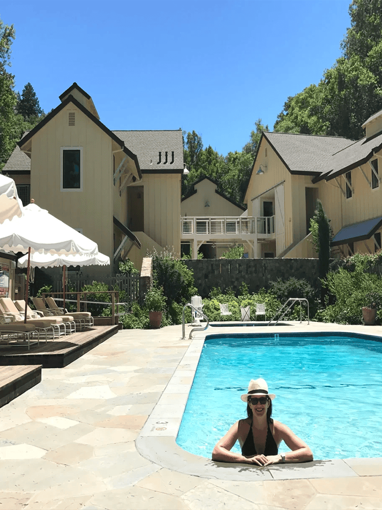 Relaxing poolside at QuestForDirections mountain resort, with cozy cottages and lush greenery in the background.