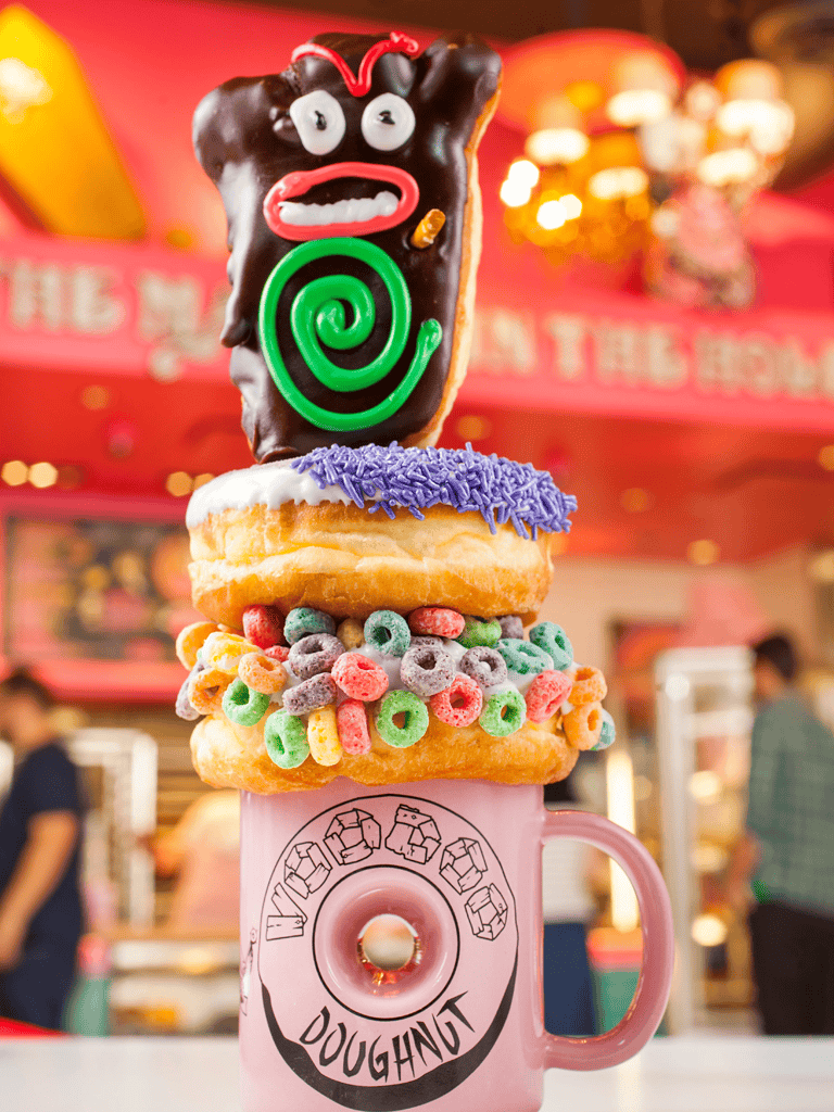 Colorful donut stacking with whimsical toppings at QuestForDirections, a playful dessert spot.