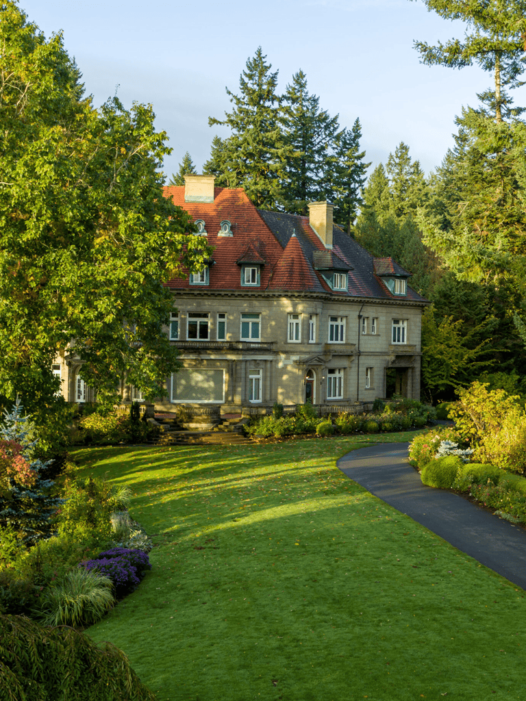 Elegant historic mansion surrounded by lush greenery and scenic landscape.