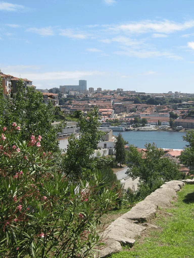 Vibrant cityscape view of Lisbon with river, historic buildings, and lush greenery in Portugal.