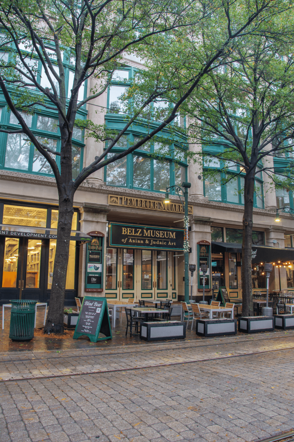Historic Asian and Judaic Art Museum on Pembrooke Square with outdoor seating and lush trees.