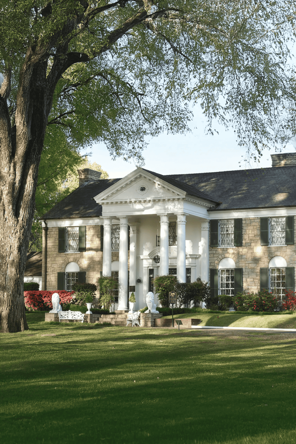 Elegant historic mansion with lush green landscaping, perfect for event venue or upscale gatherings.