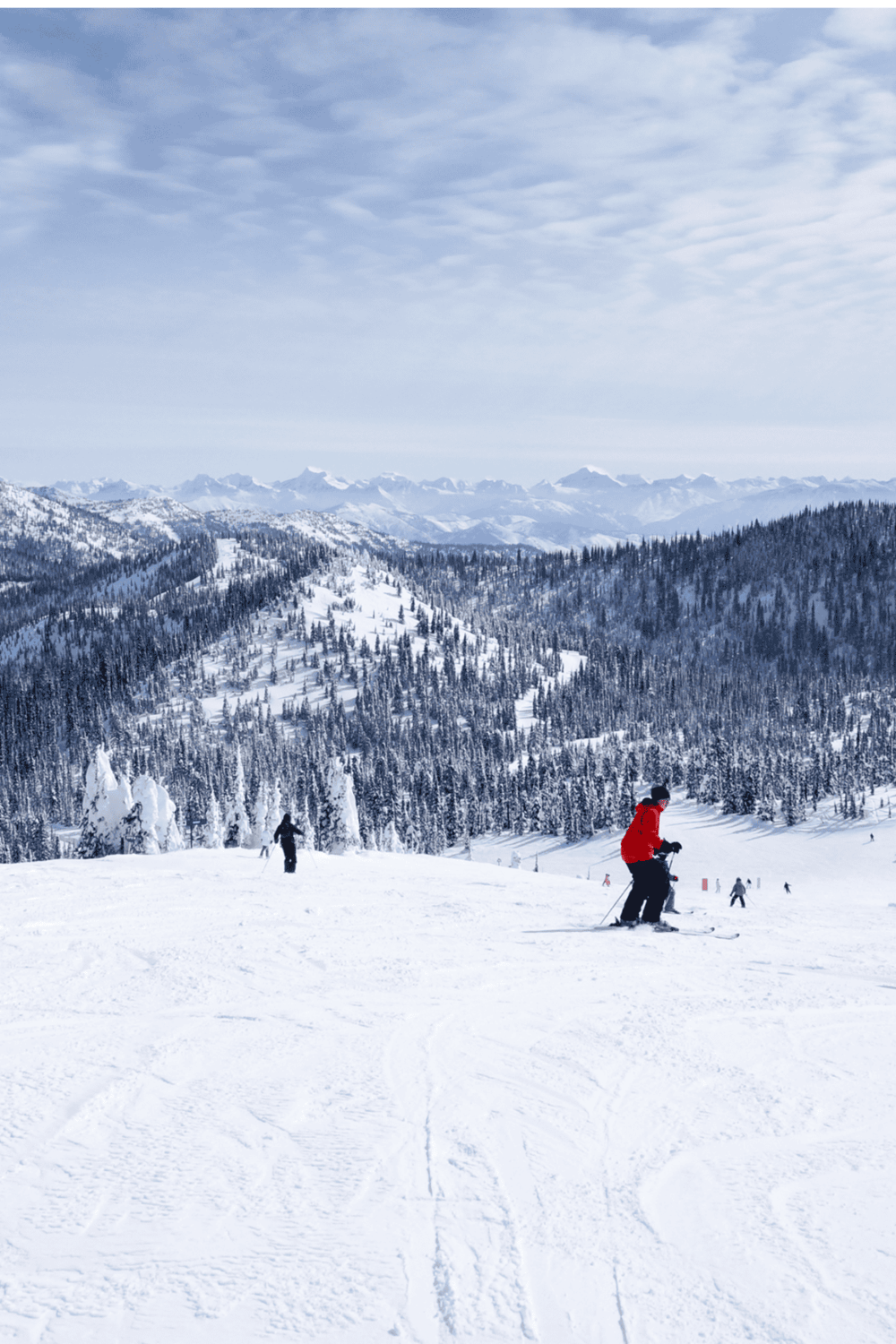 Snowy mountain ski resort with skiers and scenic alpine views for winter sports enthusiasts.