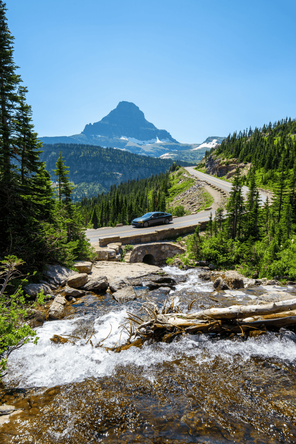Scenic mountain road with lush greenery and flowing river, perfect for travel and outdoor adventure.
