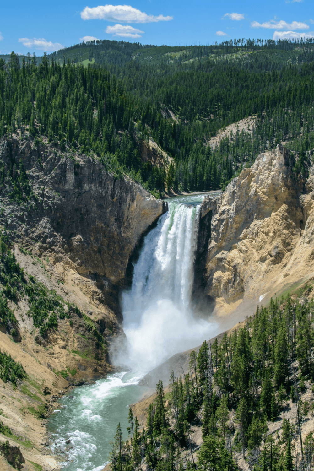 Majestic waterfall in lush forest with mountain backdrop, scenic natural beauty, and outdoor adventure.