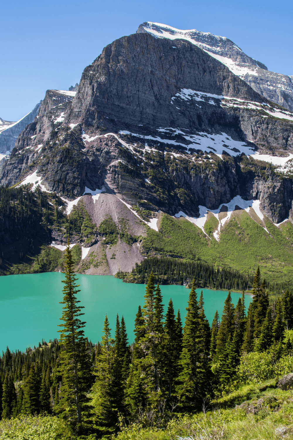 Serene mountain landscape with turquoise lake and evergreen trees, perfect for outdoor adventure and nature exploration.