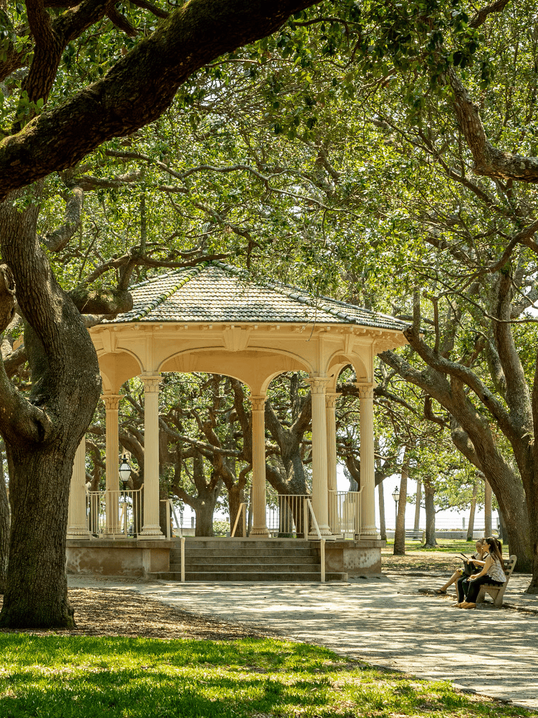 Charming park gazebo surrounded by lush trees for outdoor relaxation and scenery.