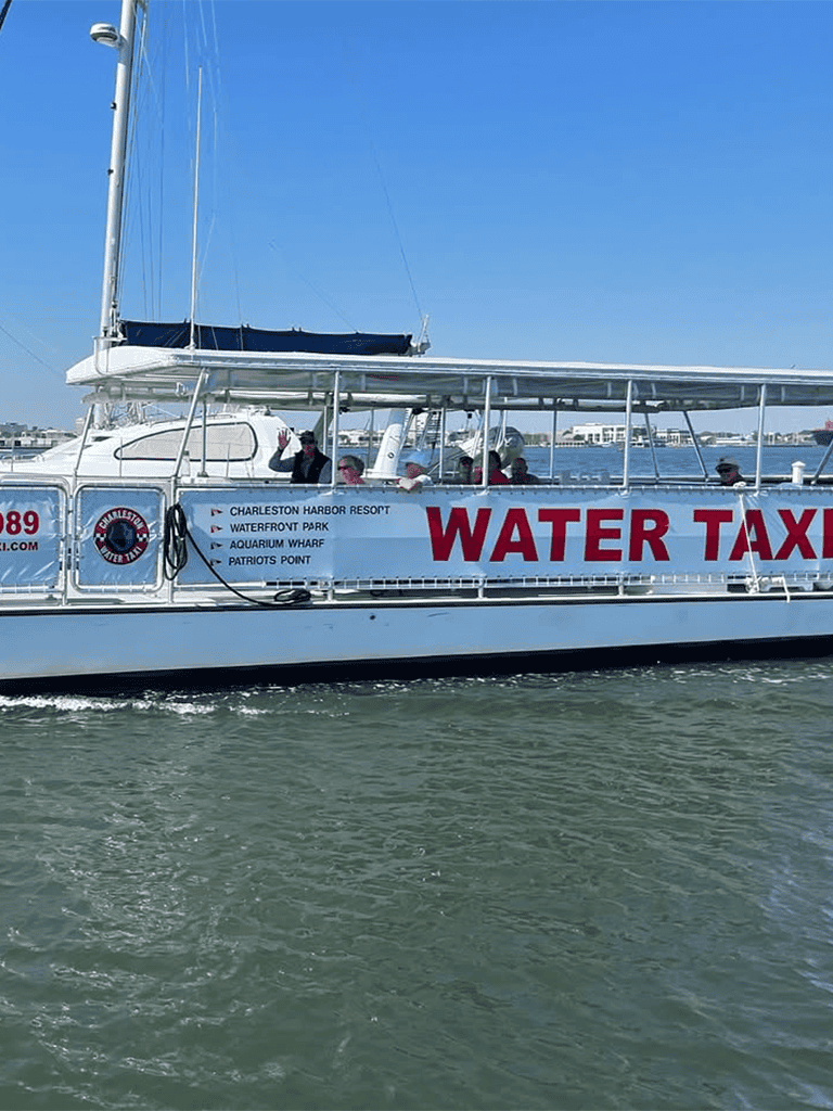Water taxi boat in Charleston harbor offering transportation to waterfront park and aquarium.