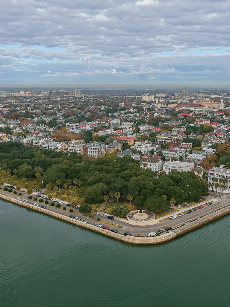 Colorful cityscape with ocean view and lush park in Savannah, Georgia.