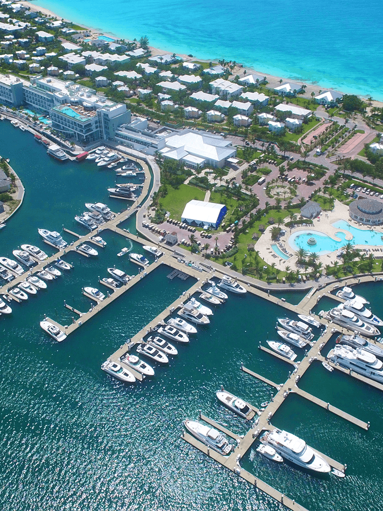 Luxury marina with yachts, waterfront resort, and beautiful tropical beach scenery.