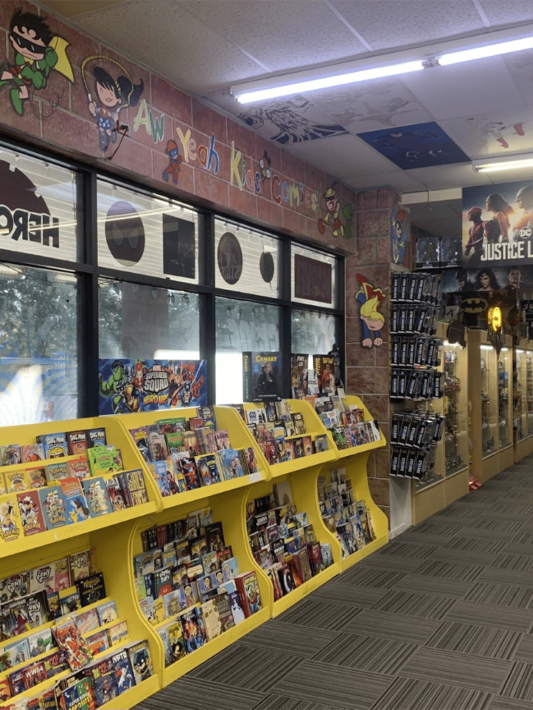 Colorful comic and book displays inside a store with cartoon decor and merchandise shelves.