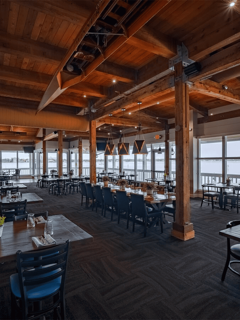 Cozy waterfront restaurant with wooden interior and panoramic water views, perfect for dining and special occasions.